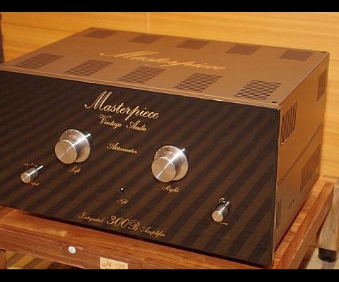 This Masterpiece Vintage Audio Amp includes an Integrated 300B amplifier boasts a dual mono design, with an elegant reflective black front panel highlighted by separate left and right channel large CNC machined gold knobs, and below them are three smaller knobs for power and input selection
